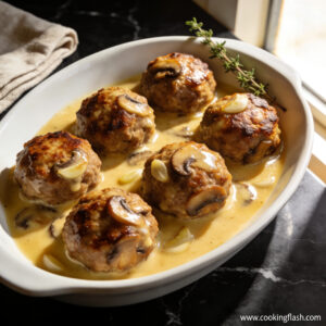 Beautifully plated high protein beef and mushroom meatballs with glossy garlic butter sauce on black marble countertop